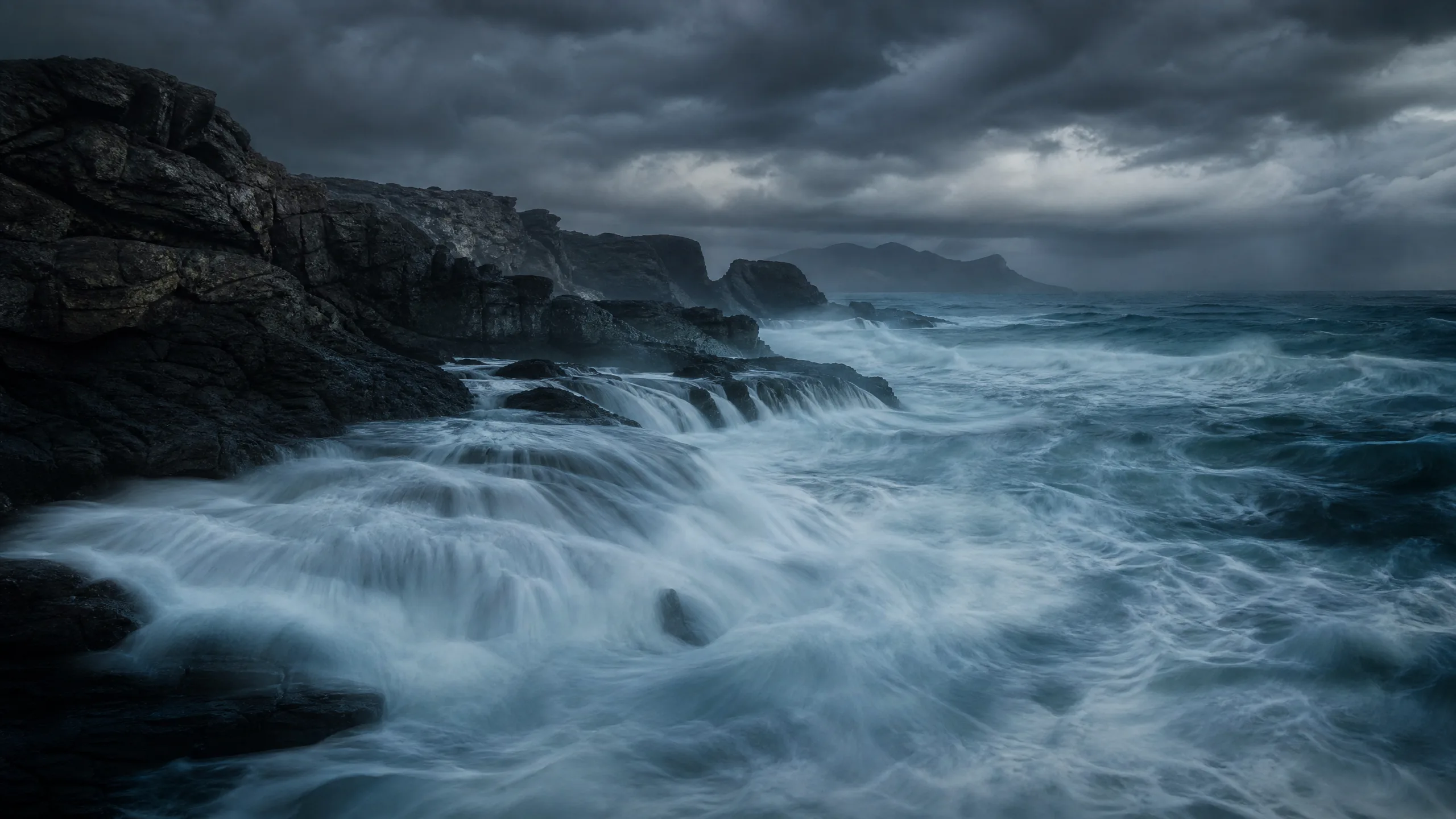 Dark storm clouds over a rugged landscape